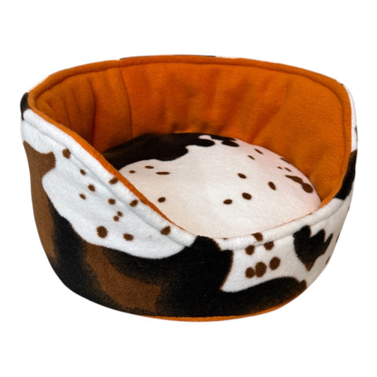 Kutuliukų puodelis – flisinis rankų darbo guolis jūrų kiaulytei, oranžinis su karvės raštu